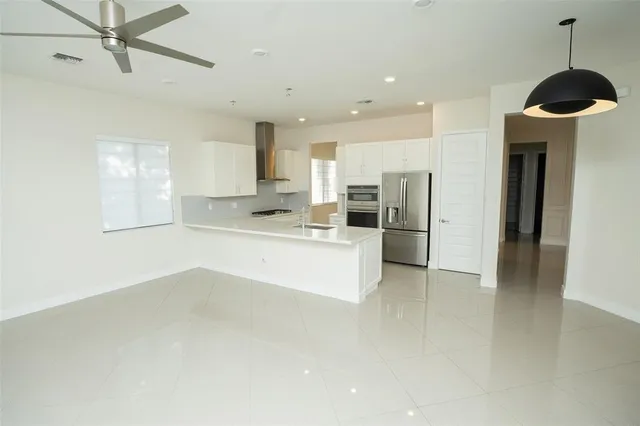 a kitchen with stainless steel appliances kitchen island a refrigerator sink and cabinets