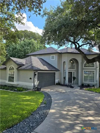 a front view of a house with a garden and trees