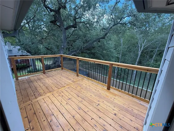 a balcony with wooden floor and fence