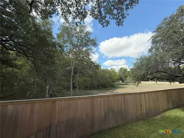 a view of a backyard with wooden fence