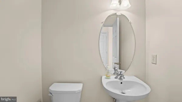 a bathroom with a toilet a sink and mirror