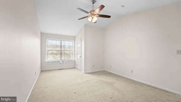 an empty room with an empty space and a ceiling fan