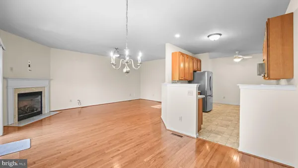 a view of a kitchen with a sink and a fireplace wooden floor cabinets
