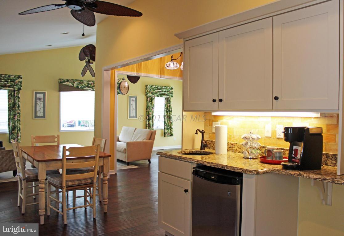 76 Pinehurst Road Ocean Pines, MD 21811 - Photo 11 of 23 a kitchen with stainless steel appliances granite countertop a stove a refrigerator a dining table and chairs with wooden floor