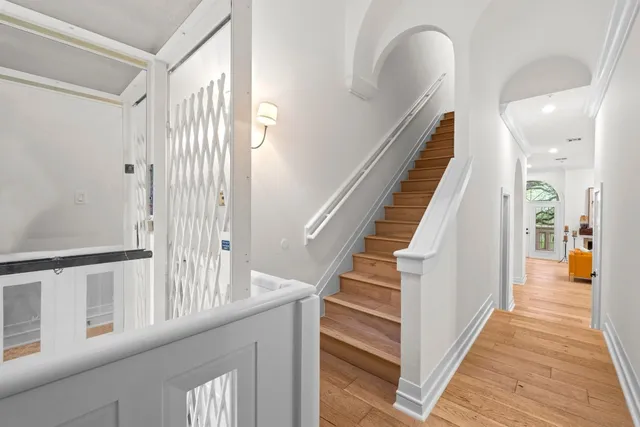 a view of a hallway with wooden floor and staircase
