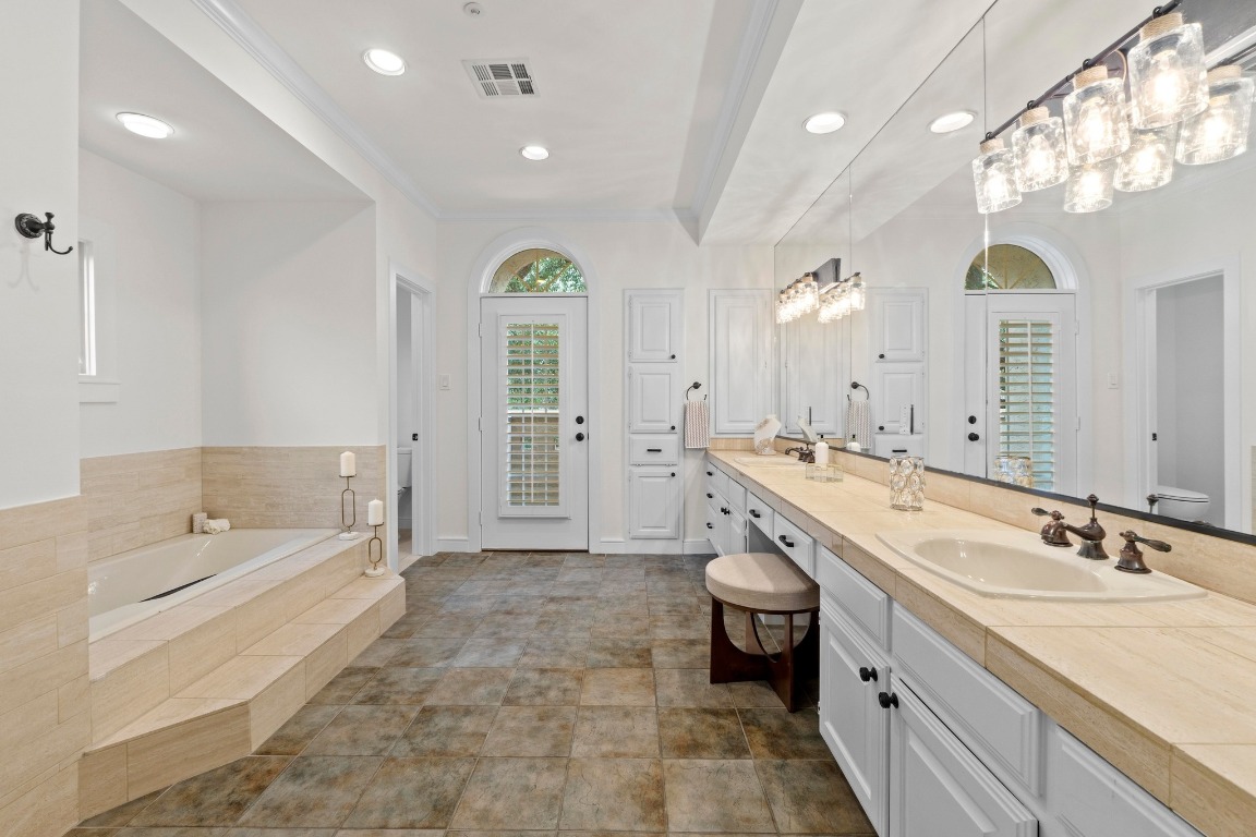 1937 Rue De St Tropez, Unit 5 Austin, TX 78746 - Photo 15 of 36 a spacious bathroom with a granite countertop double vanity sink a mirror and a bathtub