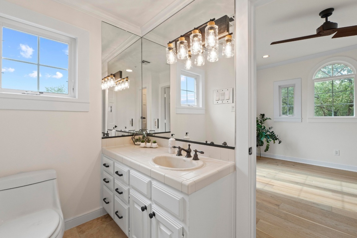 1937 Rue De St Tropez, Unit 5 Austin, TX 78746 - Photo 21 of 36 a bathroom with a sink a toilet and a mirror