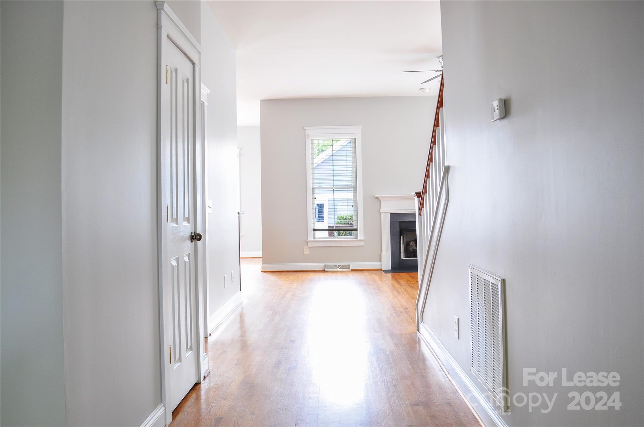 3010 Colonel Springs Way Fort Mill, SC 29708 - Photo 3 of 13 a view of a hallway to an empty room with wooden floor and a window