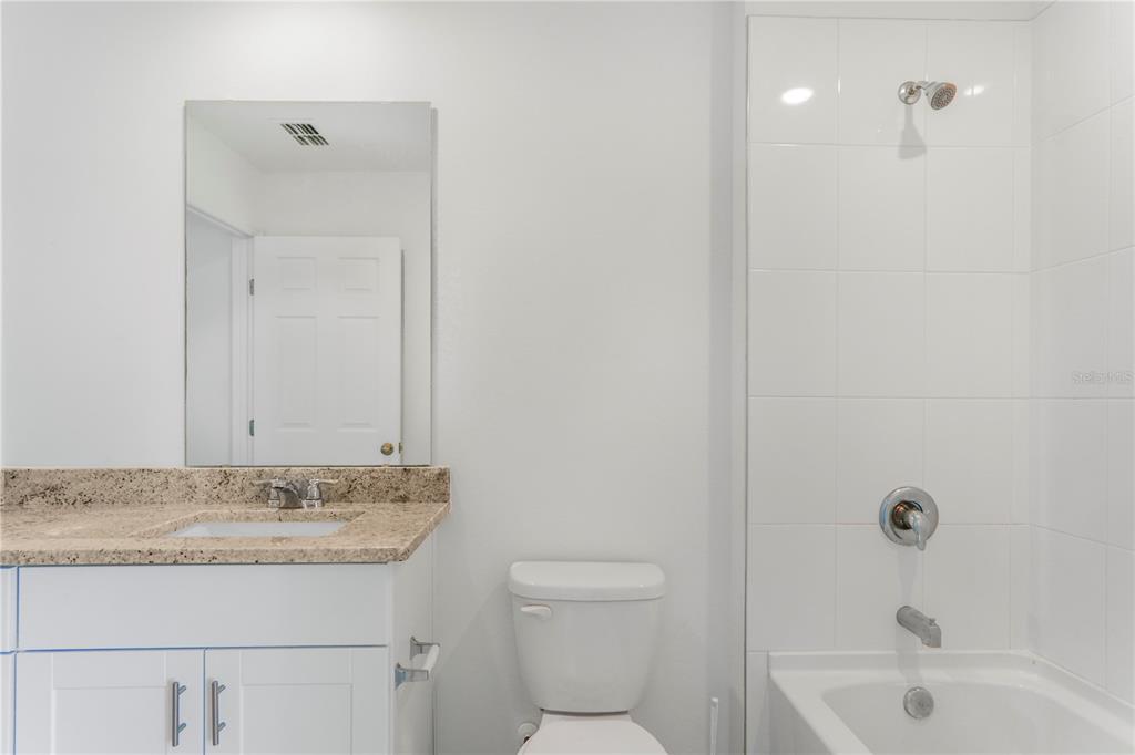 4319 Ranch House Road St. Cloud, FL 34772 - Photo 16 of 47 a bathroom with a granite countertop sink a toilet and shower