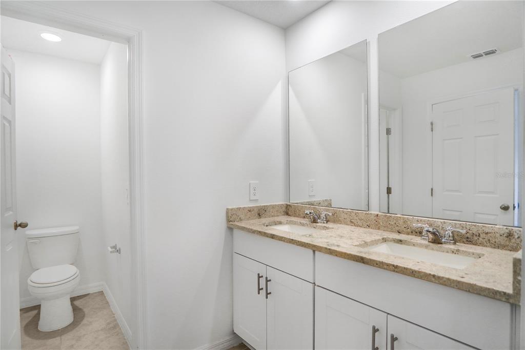 4319 Ranch House Road St. Cloud, FL 34772 - Photo 25 of 47 a bathroom with a granite countertop sink toilet and shower