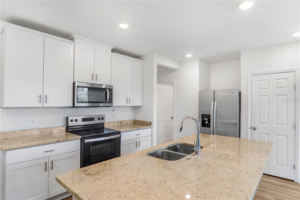 4319 Ranch House Road St. Cloud, FL 34772 - Photo 7 of 47 a kitchen with stainless steel appliances granite countertop a sink stove and refrigerator