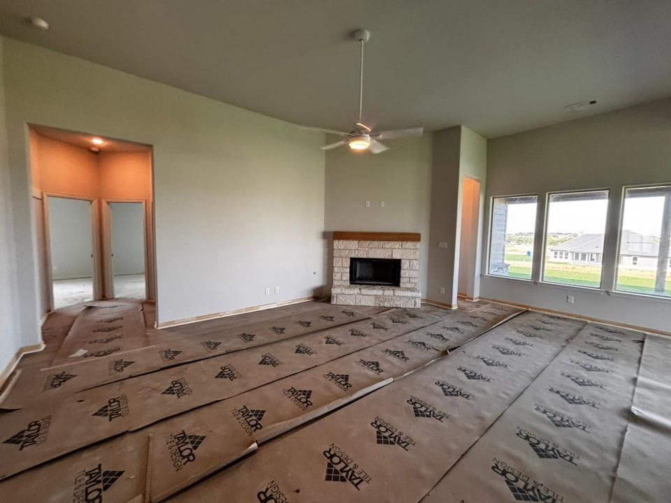 156 Hillview Trail Decatur, TX 76234 - Photo 5 of 9 Vaulted ceiling with ceiling fan, stone-surround fireplace with wood mantle, multiple large windows, and recessed lighting