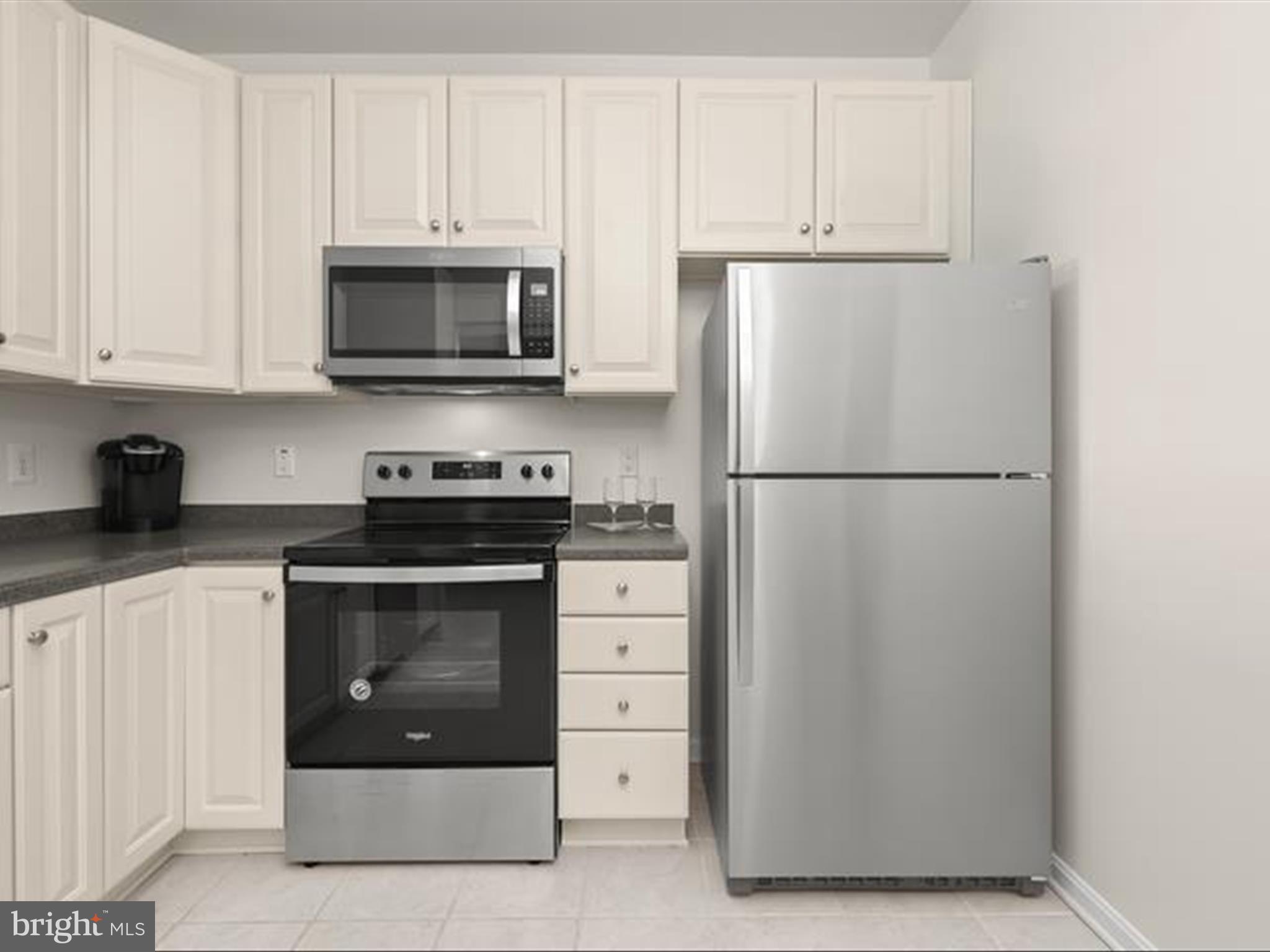 7325 Brookview Road, Unit 305 Elkridge, MD 21075 - Photo 6 of 40 a kitchen with white cabinets and stainless steel appliances
