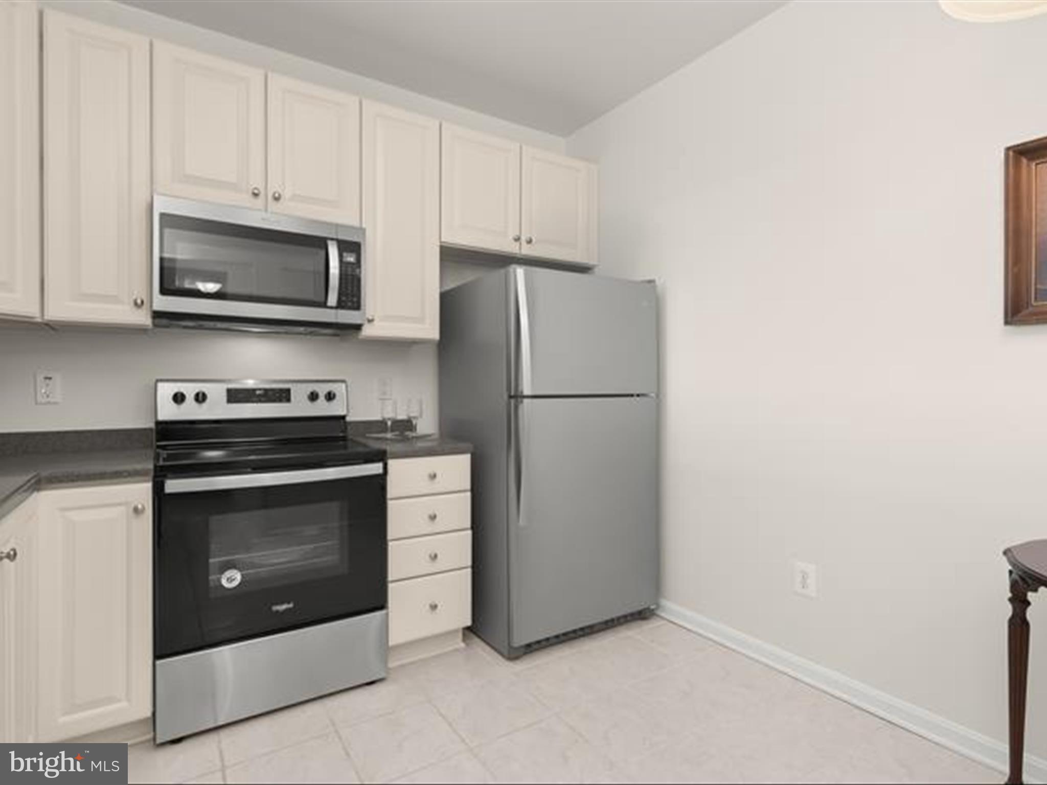 7325 Brookview Road, Unit 305 Elkridge, MD 21075 - Photo 7 of 40 a kitchen with stainless steel appliances white cabinets and a stove top oven