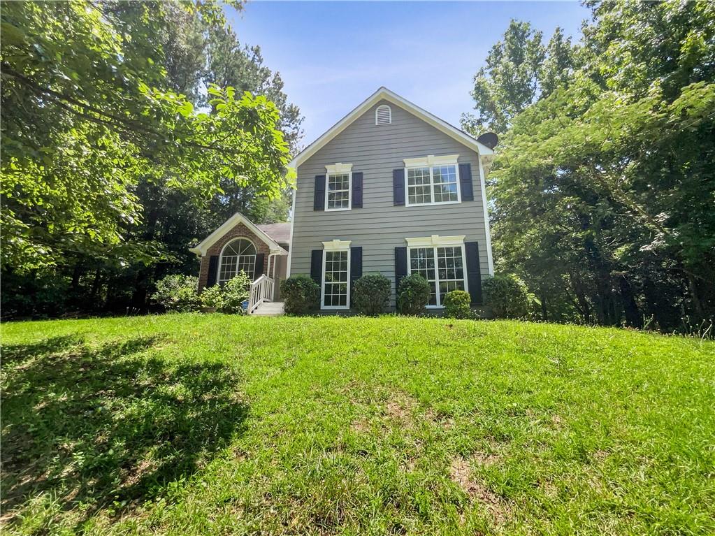 a front view of a house with yard and green space