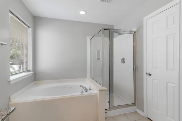 a bathroom with a bathtub a shower a sink and a window