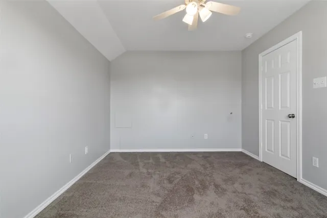 an empty room with a chandelier fan