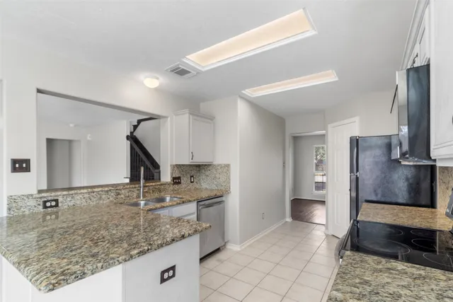 a kitchen with stainless steel appliances granite countertop a sink and a refrigerator