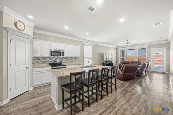 a large kitchen with a table and chairs
