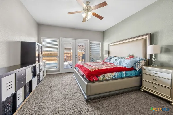 a spacious bedroom with a bed and a flat screen tv