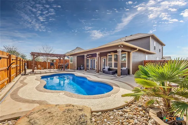 a view of a house with swimming pool and sitting area