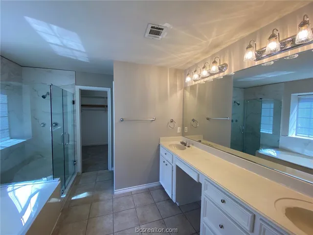 a spacious bathroom with a granite countertop sink mirror and shower