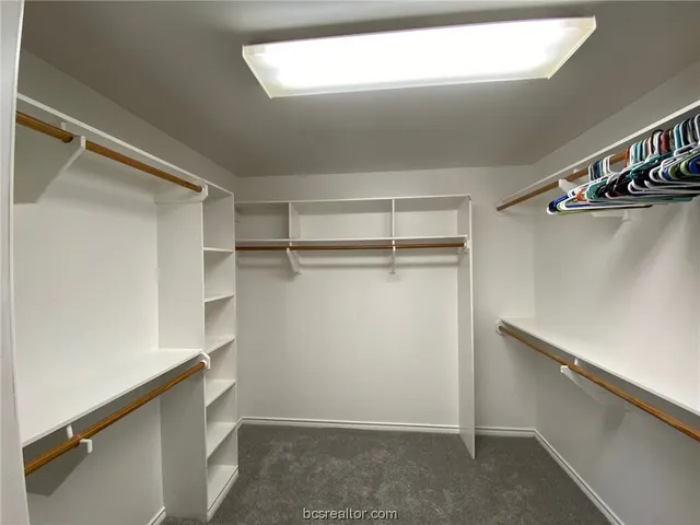 a view of walk in closet with empty racks