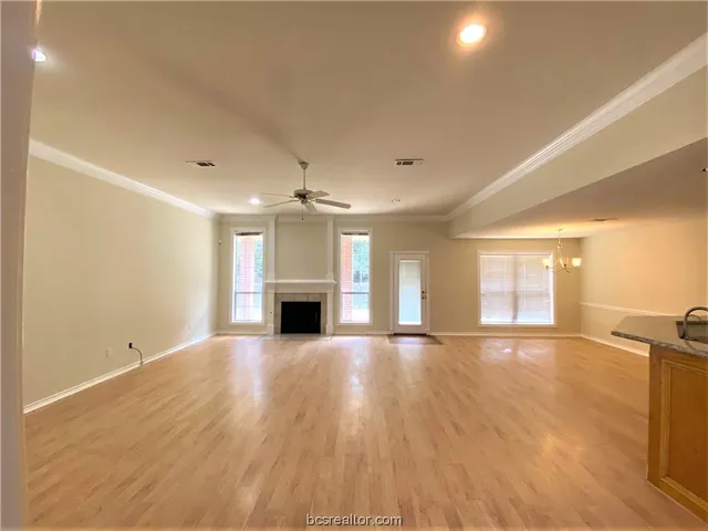 a view of an empty room with window and wooden floor