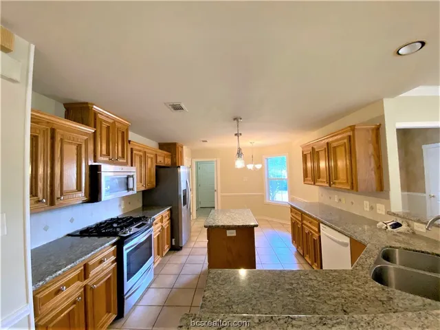 a kitchen with stainless steel appliances granite countertop a stove and a sink