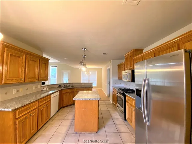 a large kitchen with cabinets and stainless steel appliances