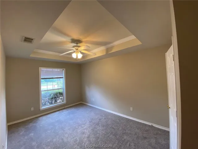 an empty room with windows and fan