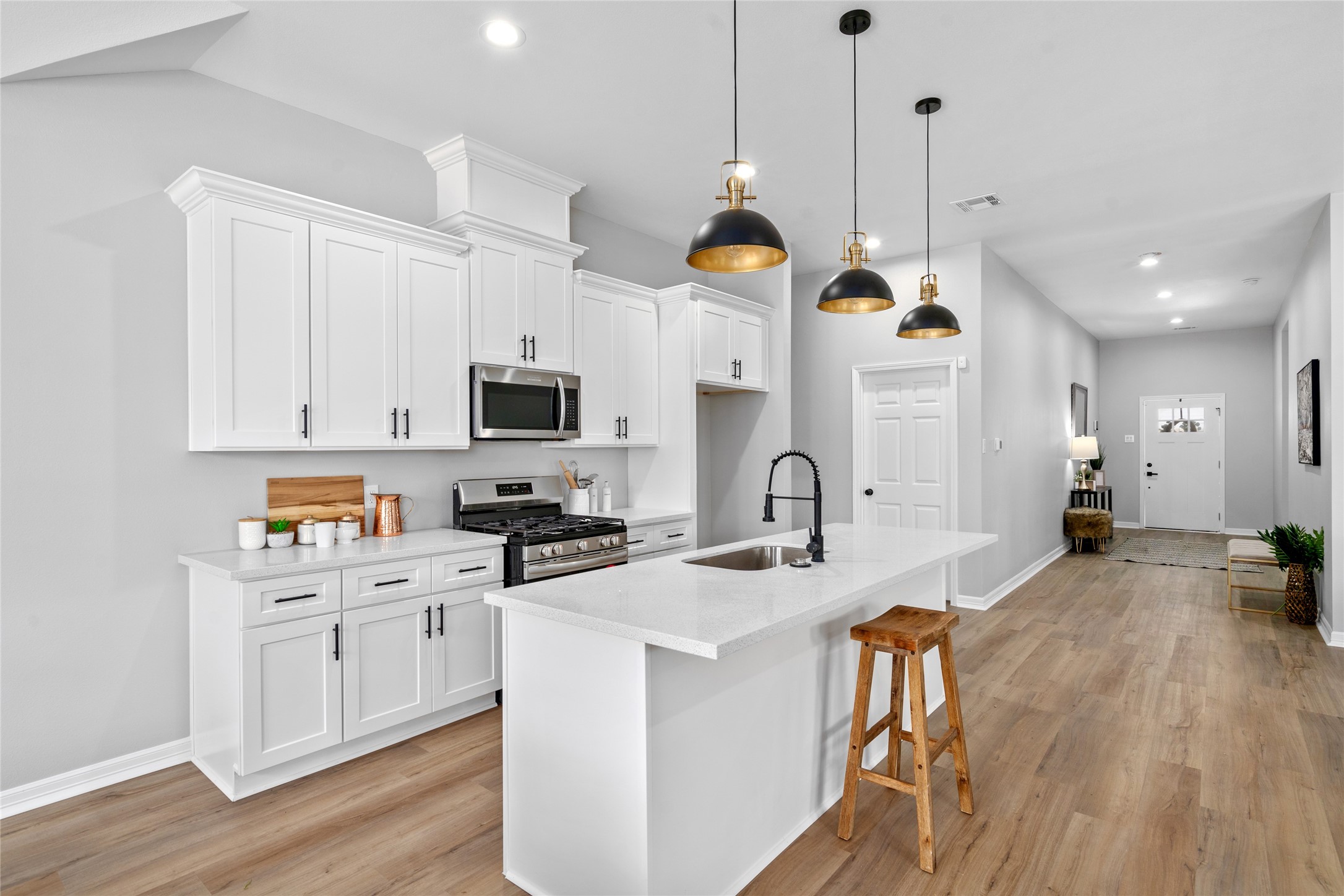 14307 Laredo Street Houston, TX 77015 - Photo 20 of 38 a open kitchen with cabinets a stove a sink a dining table and chairs with wooden floor