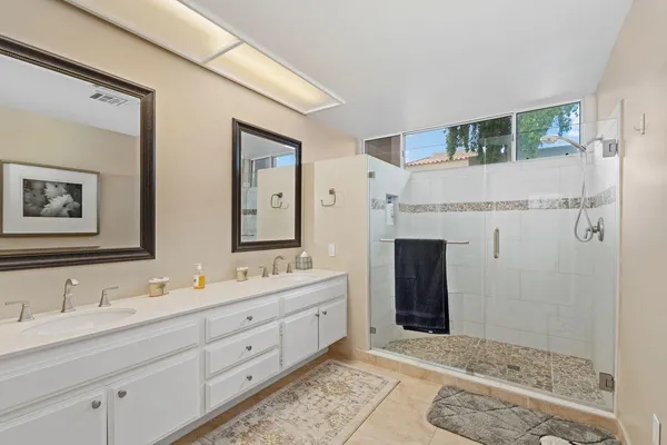a bathroom with a double vanity sink and a mirror