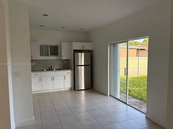 a kitchen with a refrigerator a stove top oven a sink and a window