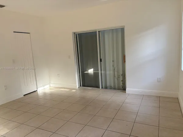 an empty room with fan and entrance