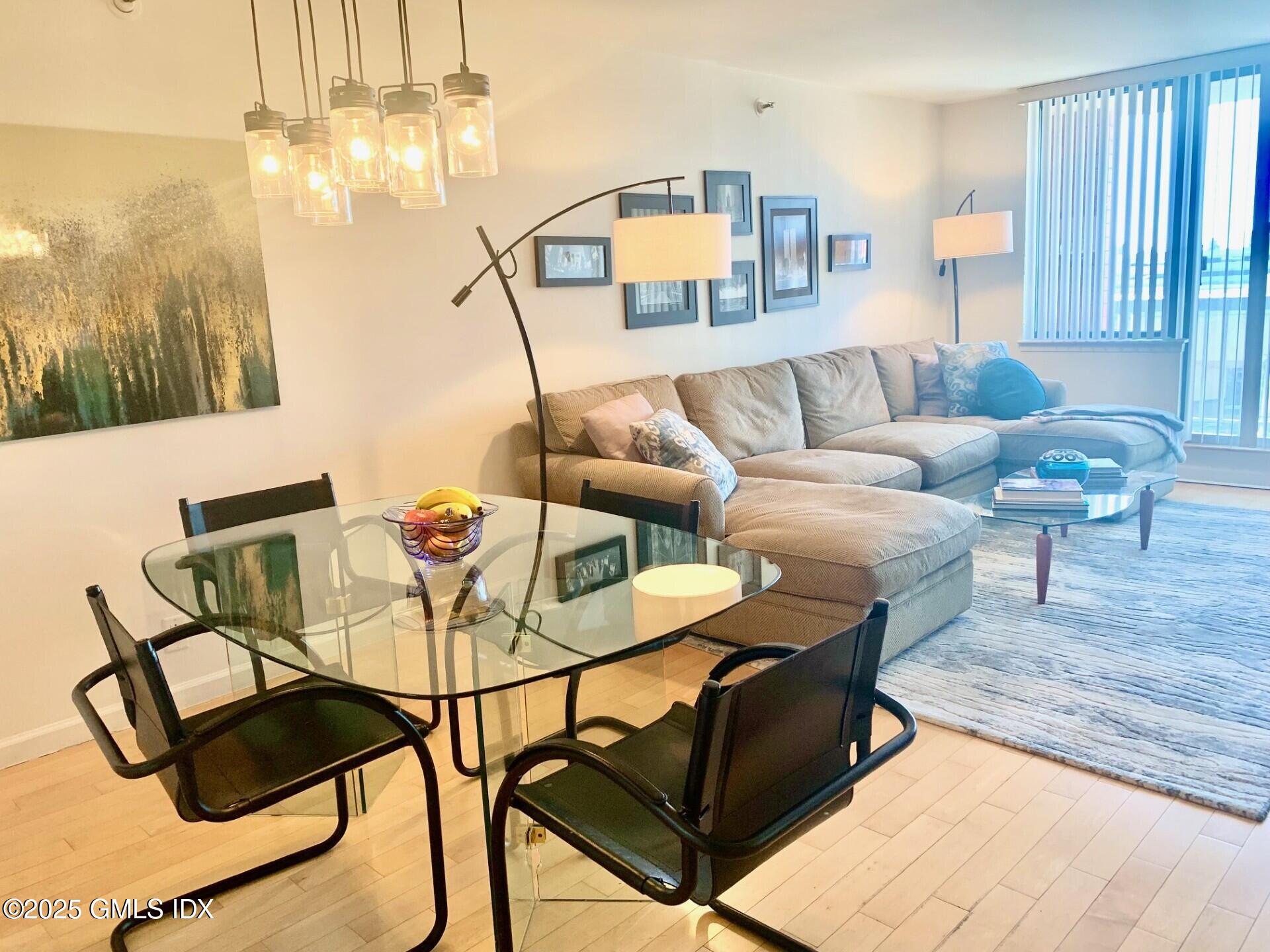 25 Forest Street, Unit 11M Stamford, CT 06901 - Photo 3 of 21 a living room with furniture a rug and a chandelier