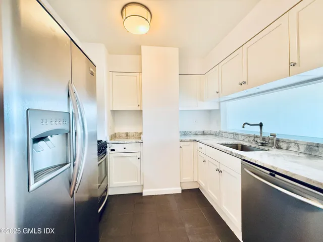 a kitchen with stainless steel appliances granite countertop a refrigerator and a sink