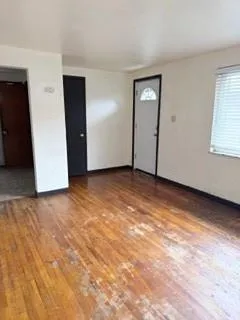 a view of an empty room with window and closet area