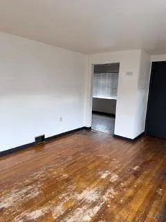 a view of an empty room with closet and a window
