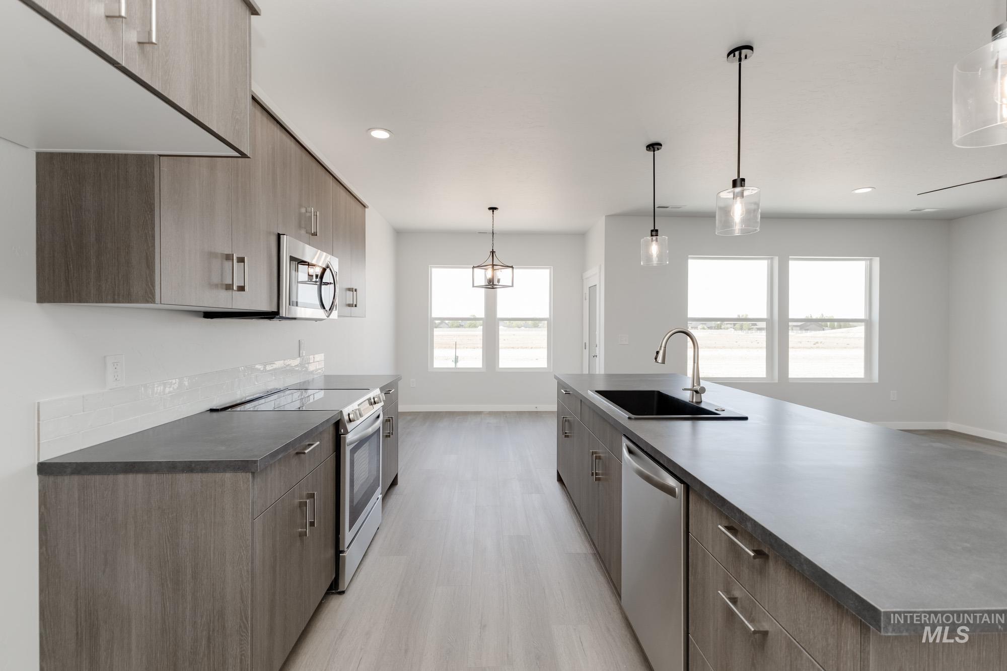 13678 Nisene Street Caldwell, ID 83607 - Photo 7 of 19 Kitchen with dark countertops, modern cabinets, appliances with stainless steel finishes, pendant lighting, and recessed lighting