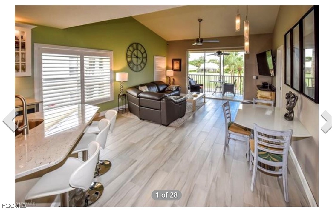 14971 Rivers Edge Court, Unit 201 Fort Myers, FL 33908 - Photo 2 of 8 a living room with furniture a flat screen tv and a large window