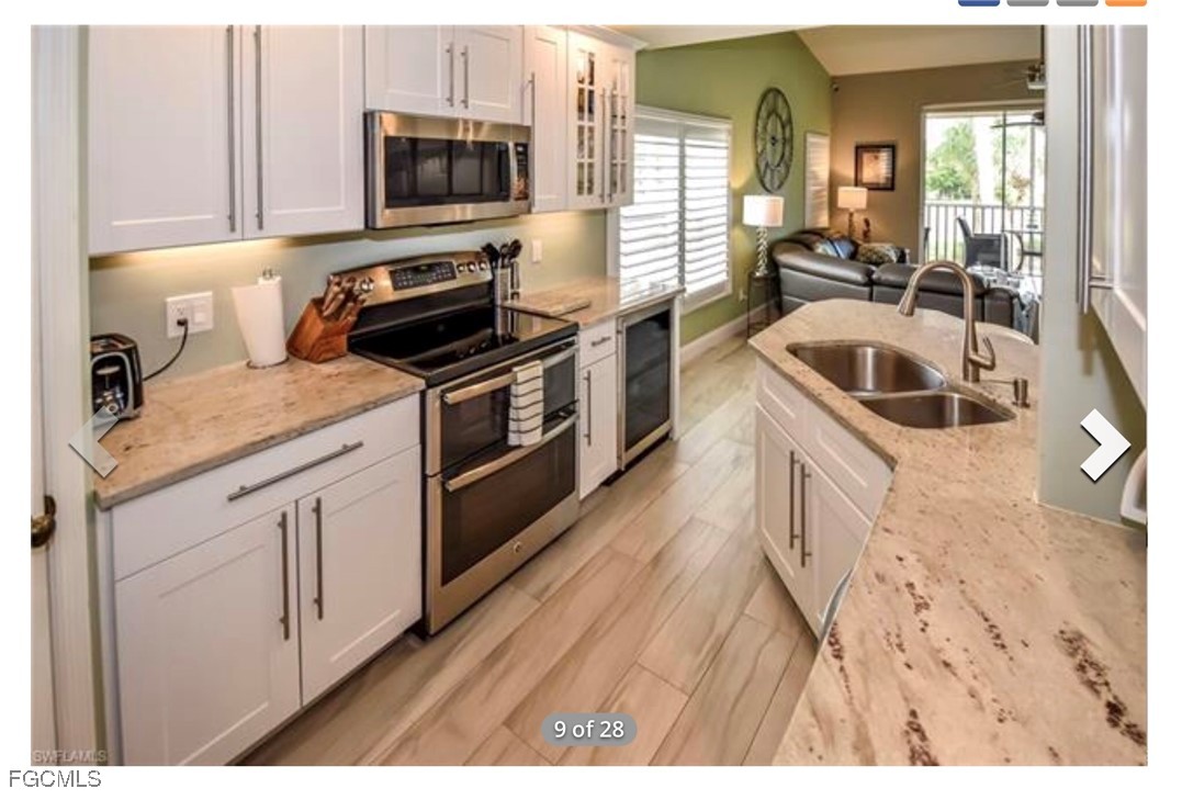 14971 Rivers Edge Court, Unit 201 Fort Myers, FL 33908 - Photo 3 of 8 a kitchen with granite countertop a sink a stove and cabinets