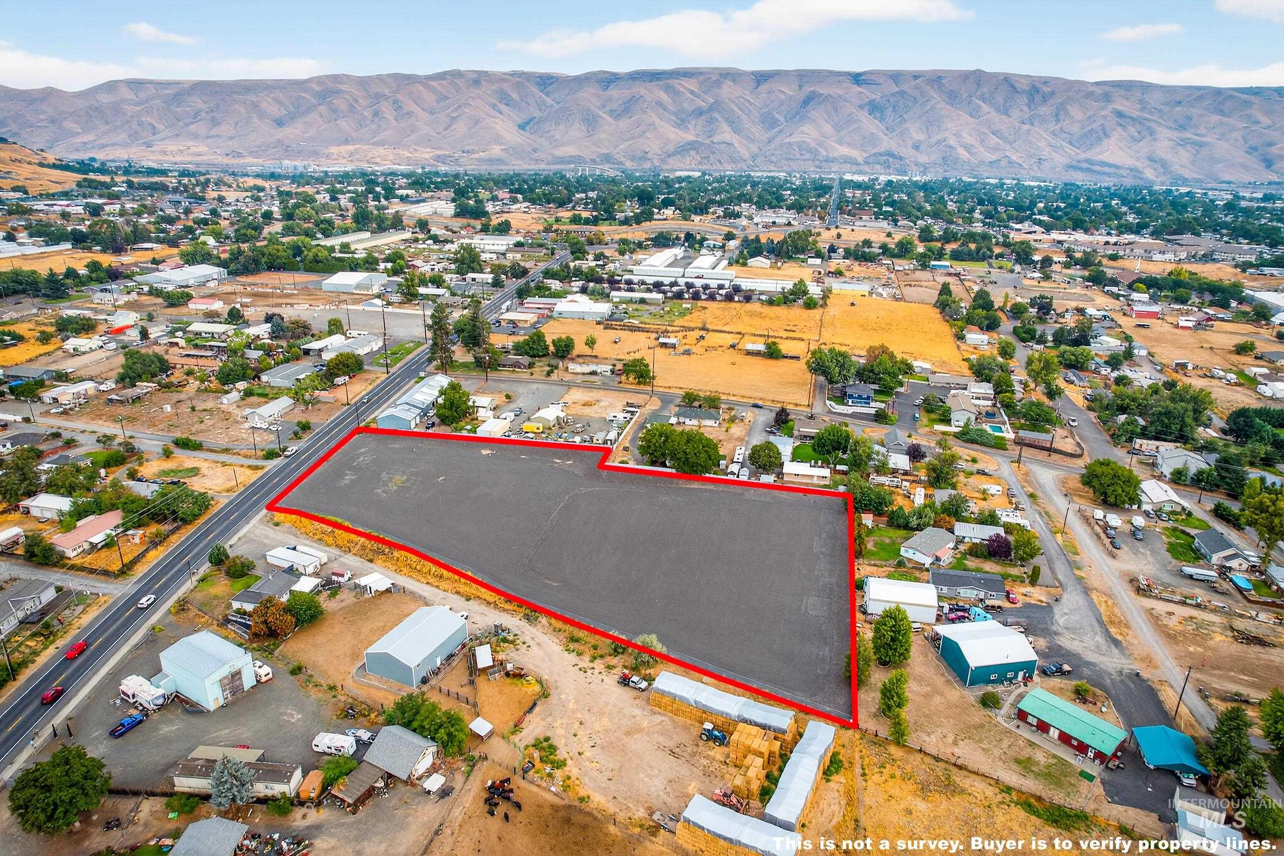 Aerial view of residential area featuring a mountain backdrop and property boundaries highlighted