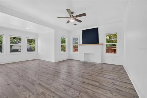 a view of an empty room with window and wooden floor