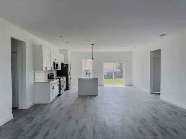 a living room with furniture and a kitchen view