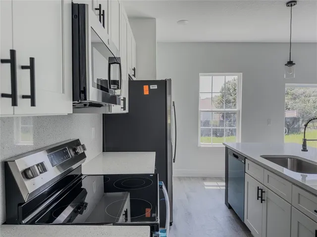 a kitchen with stainless steel appliances a stove a sink and cabinets