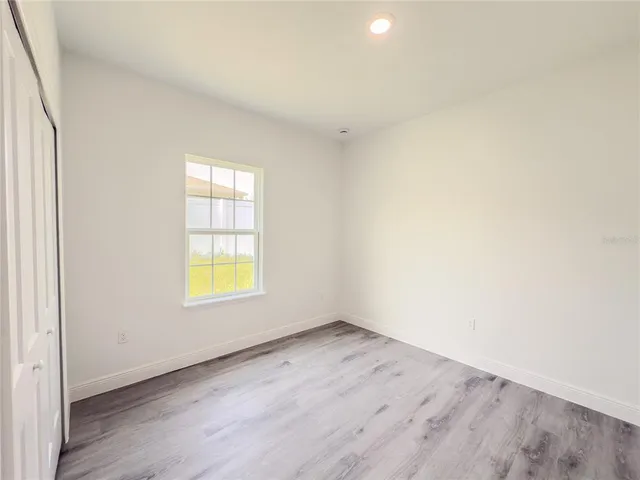 an empty room with wooden floor and a window