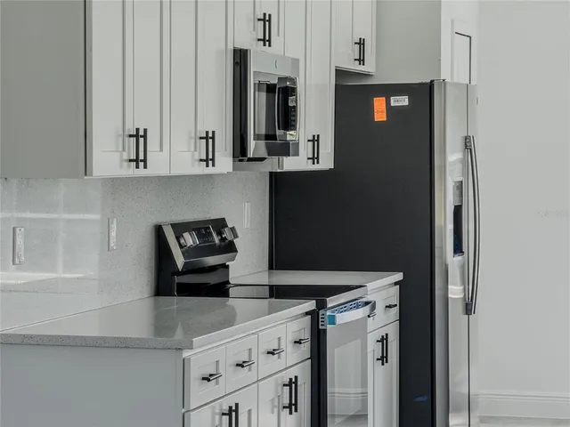 a kitchen with stainless steel appliances granite countertop a refrigerator and a stove