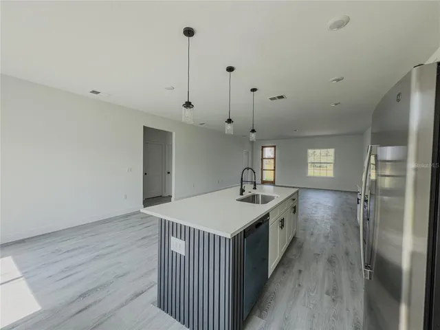 a kitchen with kitchen island a sink stove and wooden floor