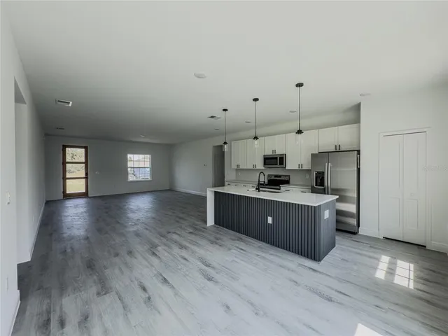 a kitchen with stainless steel appliances kitchen island wooden cabinets and window